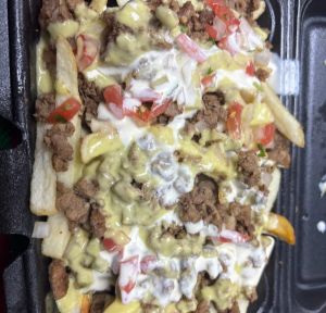 Asada fries with sauces and chopped tomato and onion