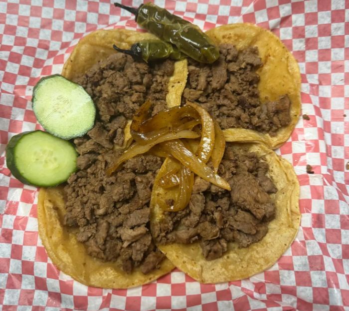 Meat tacos with grilled onions, roasted peppers and cucumber